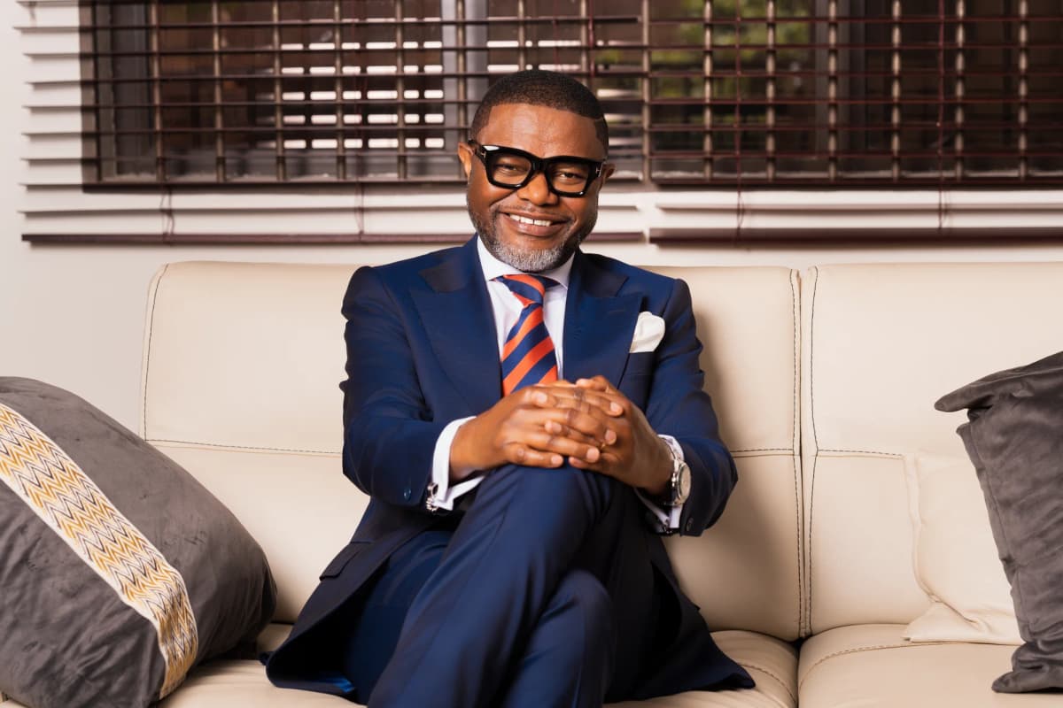 Bena Nkhoma seated in a navy suit and striped tie
